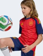 Spain Kids Home Football Kit 2026 with team crest and vibrant colors.