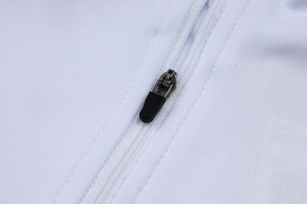 Close-up of white Adidas tracksuit zipper, showcasing quality fabric and stitching.