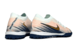 Nike Phantom GX 2 Elite TF artificial turf soccer shoes in pink, blue, and gold.