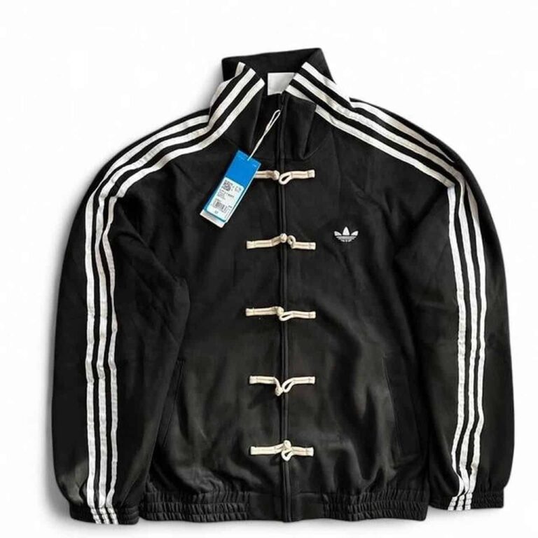 Unisex black adidas casual jacket with white stripes and toggle closures, perfect for sports and cas.