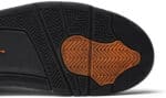 Close-up of Air Jordan 4 Retro "Undefeated" sneaker sole with black and orange details.