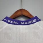 Close-up of Real Madrid jersey collar with team name on blue band.