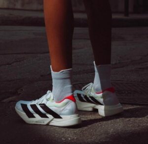 Adidas Adizero Adios Pro 4 running shoes in white, black, and red for optimal performance.