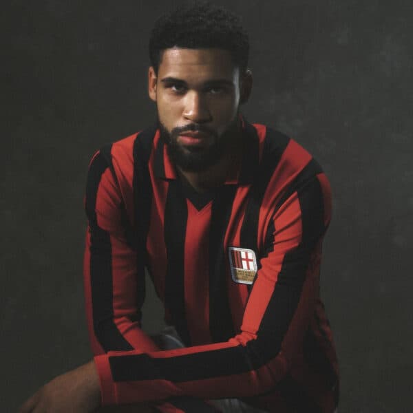 Red and black striped football jersey with crest, ideal for soccer fans and players.