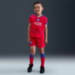 Kids PSG third football kit 2025/26 with team logo and vibrant red and blue design.