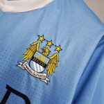 Manchester City FC limited edition football jersey with crest and Kun Agüero 2011-2012 design.