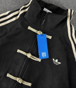 Black unisex adidas casual jacket with toggle closures and trefoil logo.
