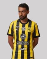 Al-Ittihad football jersey for home games, featuring yellow and black stripes, official club logos,.
