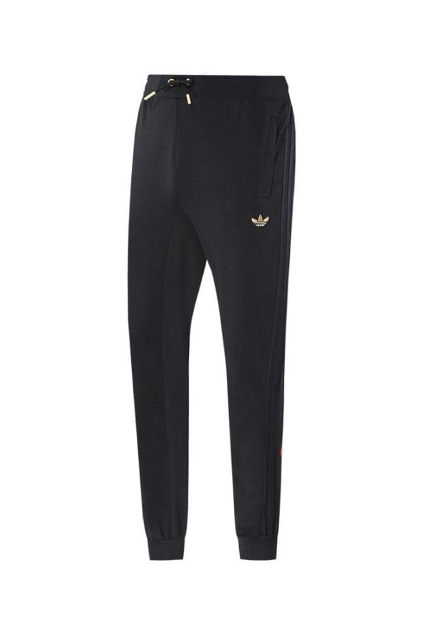 Black Adidas joggers with gold logo, comfortable sportswear for men.