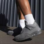 High-quality Air Jordan 4 'Wet Cement' sneakers in gray with white socks.