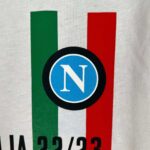 Official Napoli 2023/24 Scudetto champion jersey with team logo and colors.