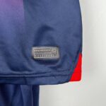 Close-up of PSG kids 2023/24 home football kit with logo and fabric details.