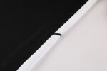 Black Nike Dri-Fit tracksuit fabric close-up with white background.