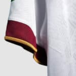 Close-up of a football jersey sleeve featuring red, white, and gold trim, highlighting quality fabri.