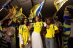 Fans wearing AL Nassr jerseys with Ronaldo 7 at a lively event.