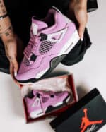 Air Jordan 4 Orchid sneaker with purple and black accents, iconic design, and premium materials.