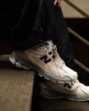 Authentic New Balance 1906R sneakers in beige and black for casual and athletic wear.