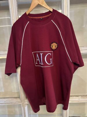 Authentic Manchester United red football jersey with club crest and AIG sponsor logo.