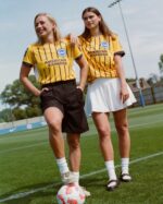 Brighton away football jersey 2024/25 with yellow and black stripes, featuring American Express logo.