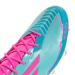 Soccer cleat with vibrant aqua, pink, and cyan colors, designed for optimal performance on firm grou.