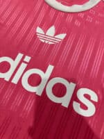 Pink Adidas sports shirt with white logo.