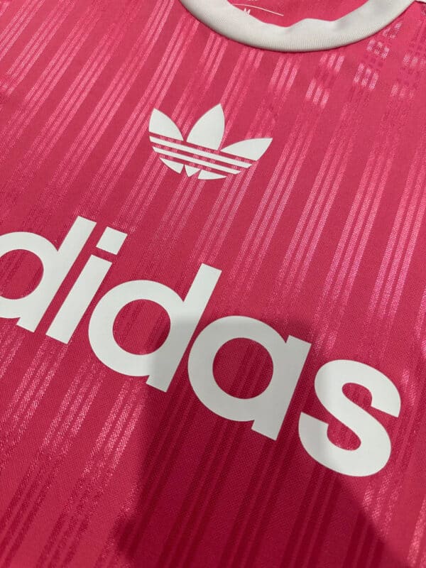 Pink Adidas sports shirt with white logo.
