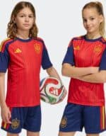 Kids Spain home football kit 2026 with team crest and vibrant red and blue design.