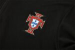 Portugal national team emblem on black training tracksuit fabric.