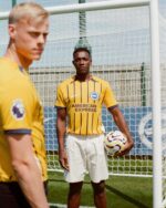 Brighton away football jersey 2024/25 with yellow and navy stripes, featuring the American Express l.