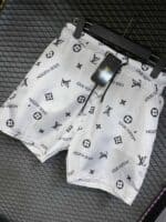 White Louis Vuitton monogram swim shorts with black logo print for men.
