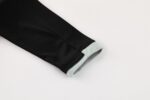 Black Nike Dri-Fit tracksuit sleeve with gray cuff detail.