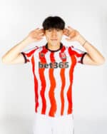 Stoke City 2025/26 home football jersey with red and white vertical stripes, featuring Bet365 sponso.