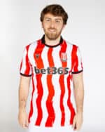 Stoke City 2025/26 home football jersey with red and white vertical stripes, official club crest, an.
