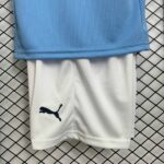 Kids football shorts with Puma logo, white color, part of Manchester City home kit 2025/26.