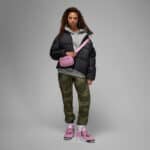 Woman wearing pink Air Jordan 4 Orchid sneakers with casual outfit.