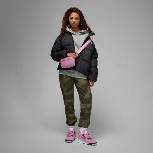 Woman wearing pink Air Jordan 4 Orchid sneakers with casual outfit.