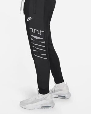 Black Nike training pants with gray "NIKE" logo and Nike swoosh, tapered fit, for sports and workout.