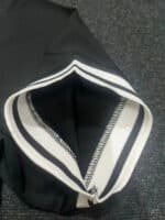 Close-up of black Nike football jersey collar with white stripes.