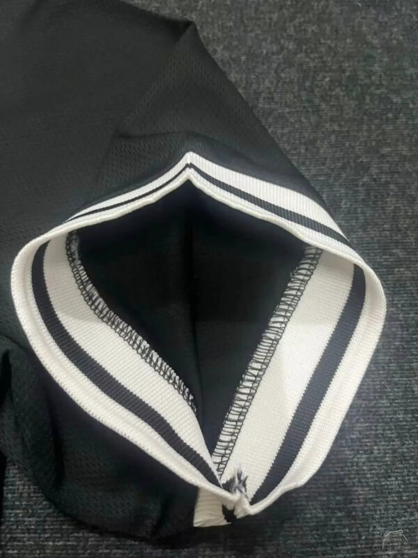 Close-up of black Nike football jersey collar with white stripes.