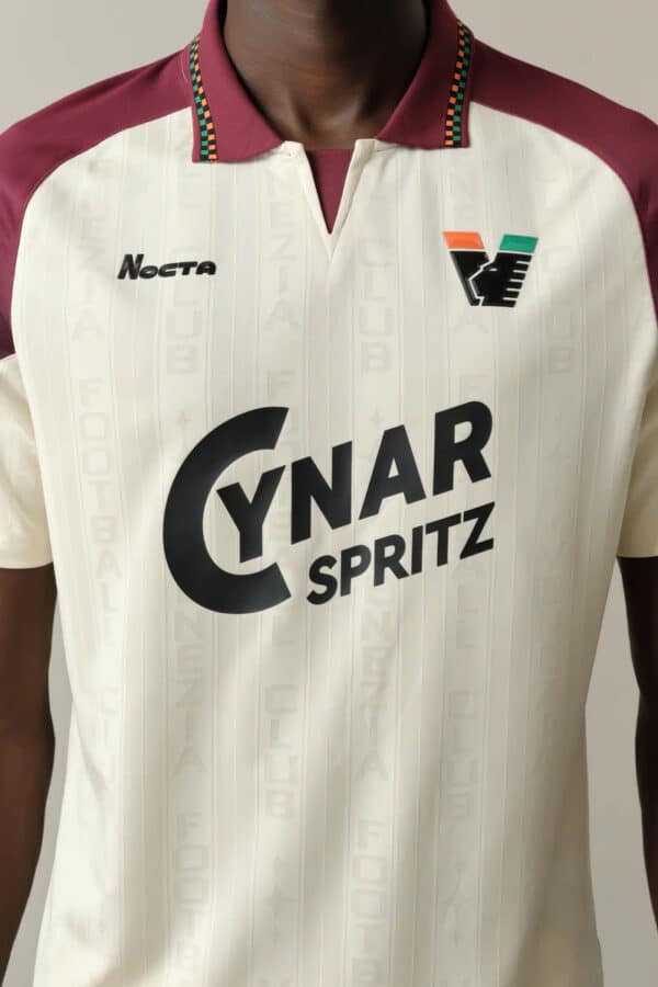 Football jersey with sponsor logos, colorful collar, and team branding for sports fans.