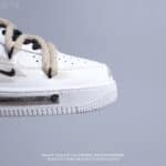 Nike Air Force Low 1 in white with light beige accents, close-up view.