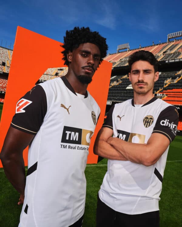 Soccer players wearing Valencia CF jerseys at stadium.