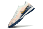 Athletic Nike Phantom GX 2 Elite TF artificial turf soccer shoe in pink, blue, and gold for optimal.