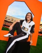 Female football player in Valencia CF kit at stadium.