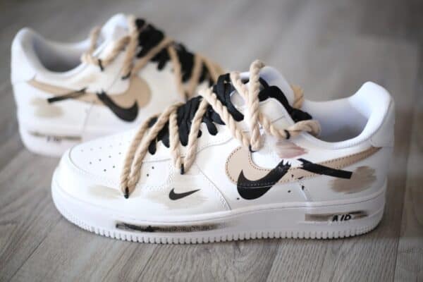 Air Force Low 1 White Light Beige sneakers with black Nike swoosh and beige accents.