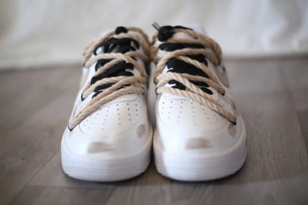 Air Force Low 1 white sneakers with light beige accents and black laces.