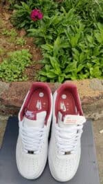 Air Force Low 1 sneakers in white with red accents, perfect for sports and casual wear.