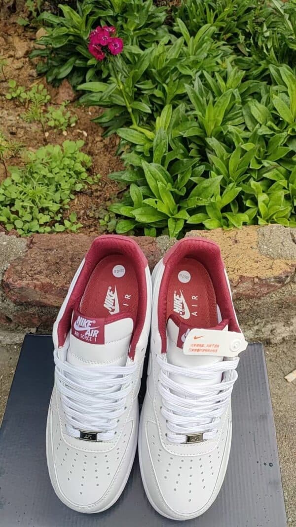 Air Force Low 1 sneakers in white with red accents, perfect for sports and casual wear.