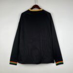 Black football jersey with vibrant orange, green, and black striped cuffs, perfect for sports fans a.