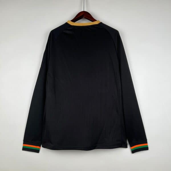Black football jersey with vibrant orange, green, and black striped cuffs, perfect for sports fans a.